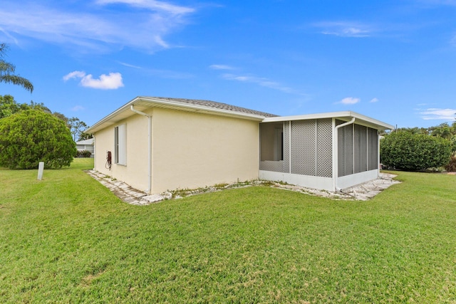 rear view of property featuring a sunroom and a lawn