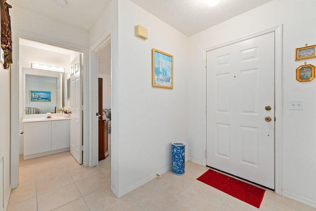 tiled foyer entrance with a textured ceiling