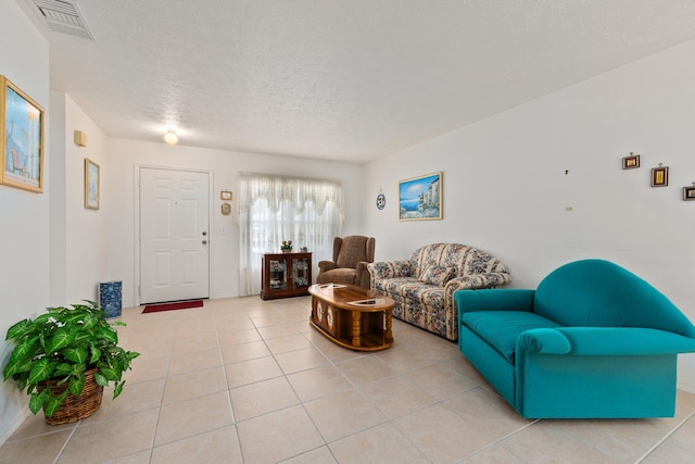 living room with a textured ceiling and light tile patterned floors