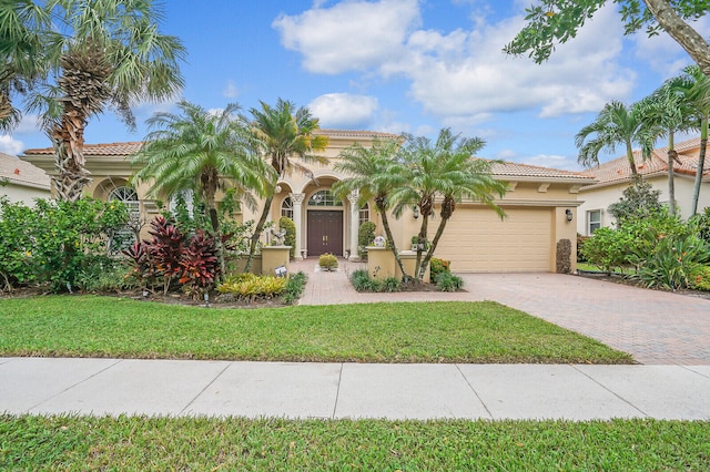 mediterranean / spanish house with a front yard and a garage