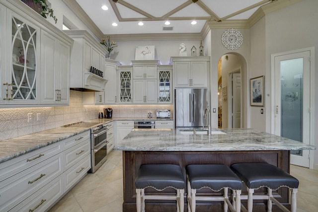 kitchen with a kitchen island with sink, a kitchen bar, and stainless steel appliances