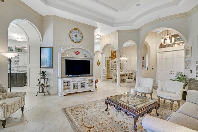 living room with a towering ceiling, crown molding, a chandelier, and light tile patterned floors