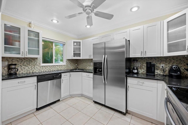 kitchen with appliances with stainless steel finishes, tasteful backsplash, ornamental molding, sink, and white cabinetry