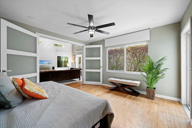 bedroom featuring multiple windows, light hardwood / wood-style floors, and ceiling fan