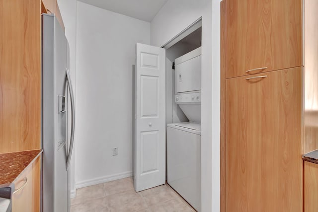 washroom featuring light tile patterned floors and stacked washer and dryer