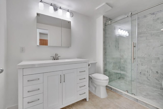 bathroom with vanity, tile patterned flooring, toilet, and a shower with door