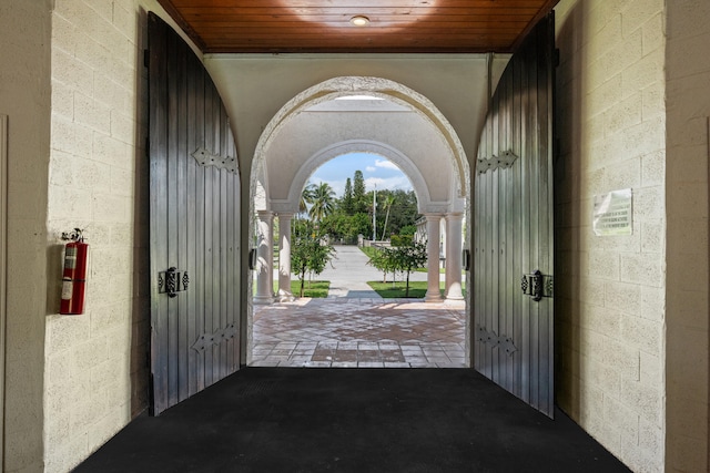 entrance foyer featuring ornate columns and wood ceiling