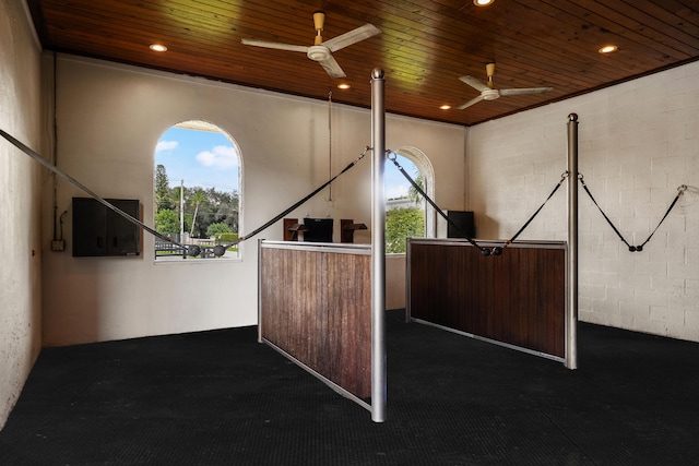 tiled spare room featuring ceiling fan and wood walls