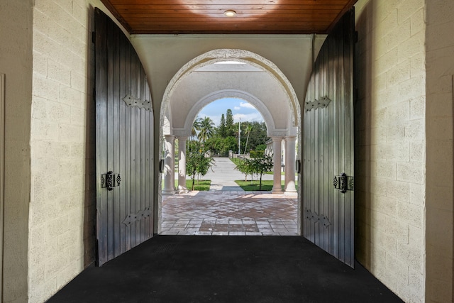 entryway featuring ornate columns and wood ceiling