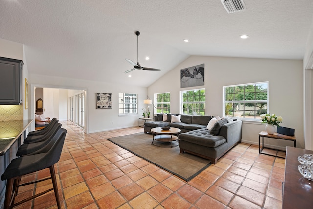 living room featuring ceiling fan, high vaulted ceiling, and a textured ceiling