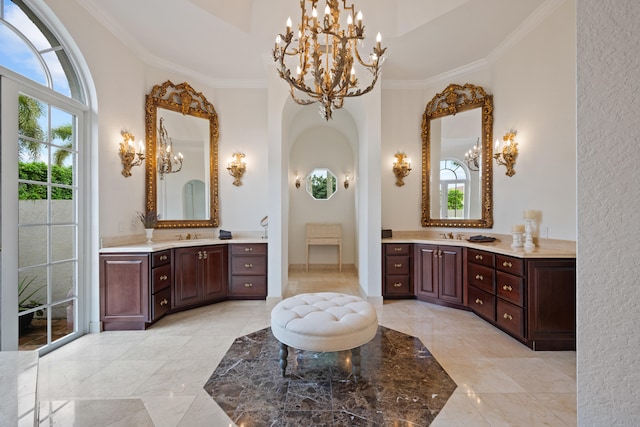 bathroom featuring vanity, ornamental molding, tiled bath, and a towering ceiling