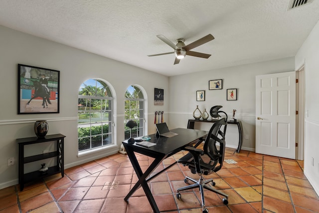 tiled office space featuring ceiling fan and a textured ceiling