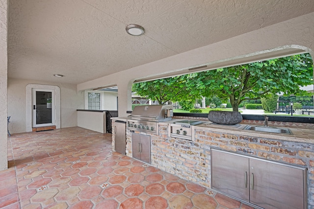 view of patio with an outdoor kitchen, area for grilling, and sink