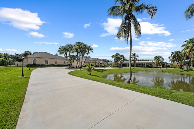 view of home's community featuring a water view and a lawn