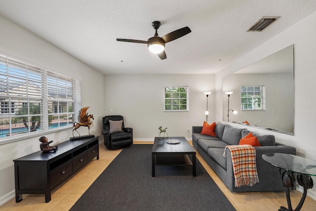 tiled living room featuring a textured ceiling and ceiling fan