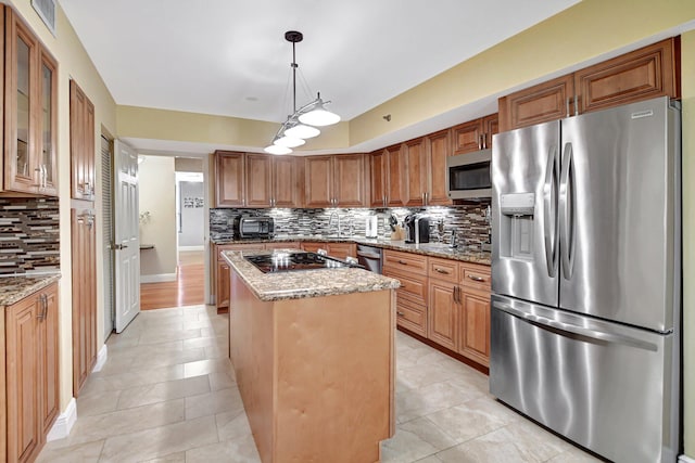 kitchen featuring backsplash, appliances with stainless steel finishes, a center island, and pendant lighting