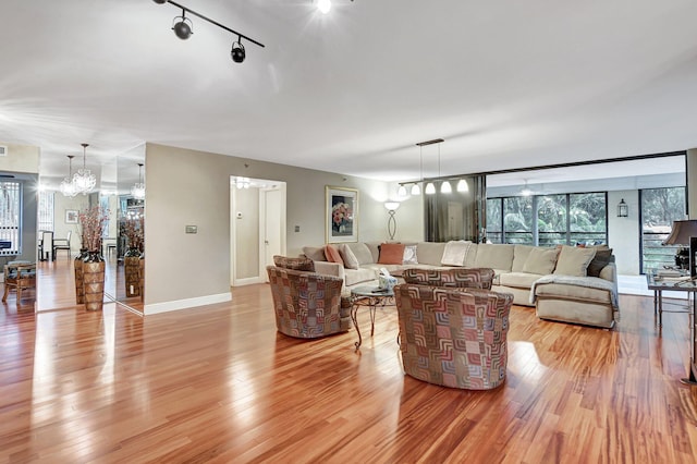 living room featuring light hardwood / wood-style flooring and an inviting chandelier