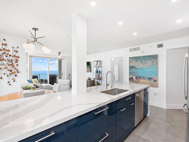 kitchen featuring blue cabinetry, stainless steel dishwasher, light stone countertops, and sink