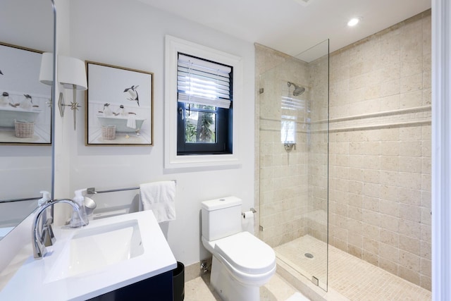 bathroom featuring vanity, tiled shower, and toilet