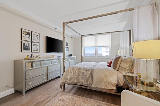 bedroom with ornamental molding and hardwood / wood-style floors