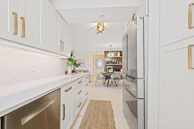 kitchen with light tile patterned floors, an inviting chandelier, white cabinetry, decorative light fixtures, and stainless steel appliances