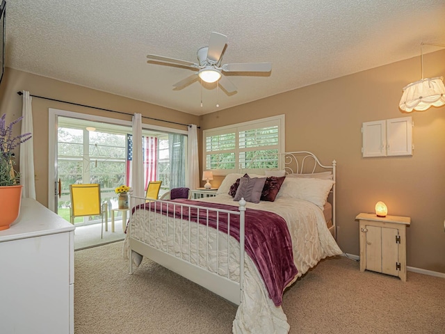 bedroom featuring light carpet, ceiling fan, baseboards, and a textured ceiling