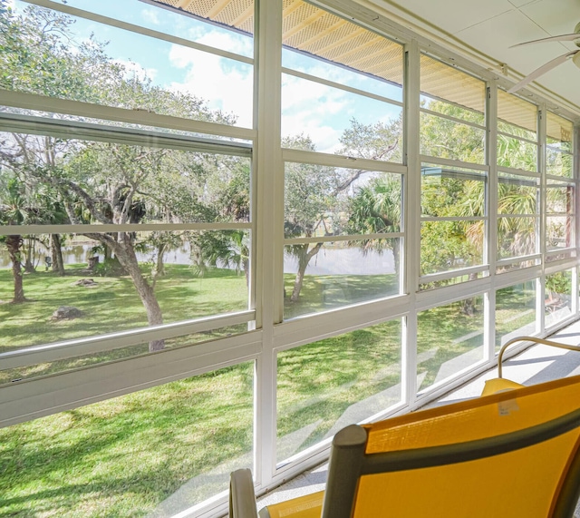 unfurnished sunroom with a water view and ceiling fan