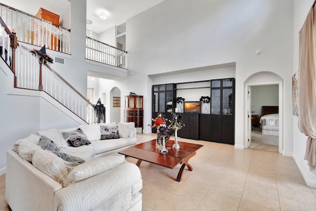 living room featuring a towering ceiling and light tile patterned floors