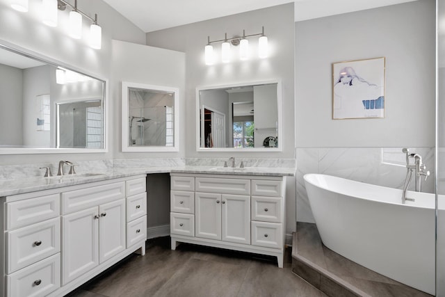 bathroom with vanity, tile walls, wood-type flooring, and separate shower and tub