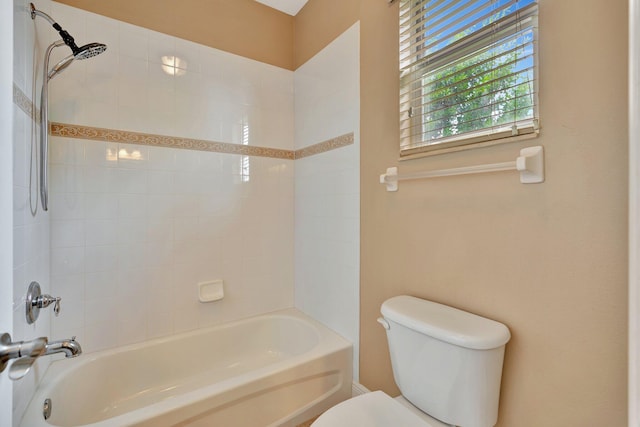 bathroom featuring toilet and tiled shower / bath combo