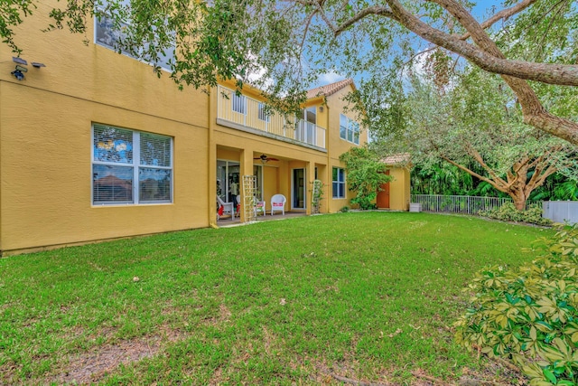 back of house featuring a patio area, a lawn, and a balcony