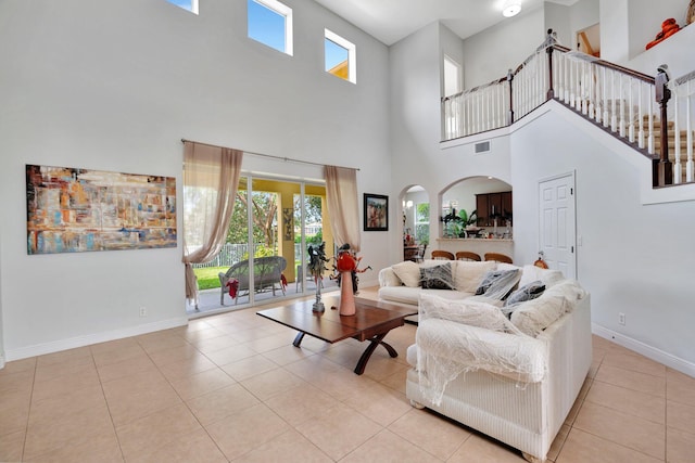 living room with a high ceiling and light tile patterned floors