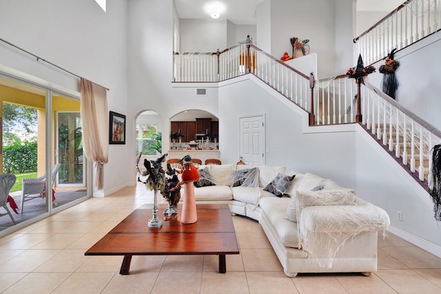 tiled living room featuring a high ceiling