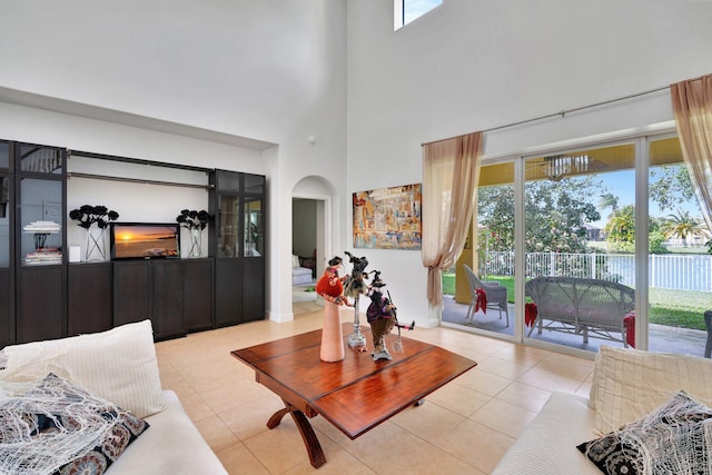 tiled living room featuring a healthy amount of sunlight and a high ceiling