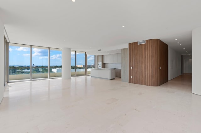 unfurnished living room with a water view and a wall of windows