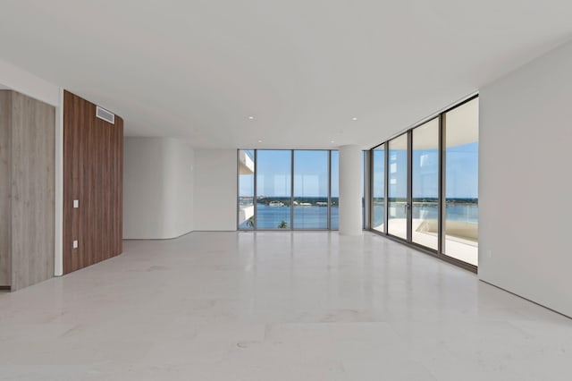 empty room featuring a water view and expansive windows