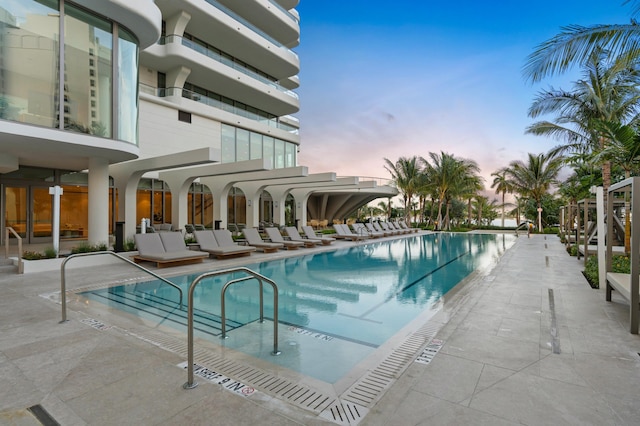 pool at dusk featuring a patio area