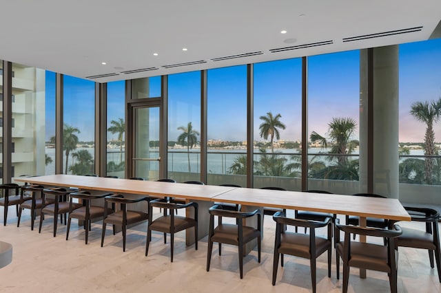 dining area featuring floor to ceiling windows, a wealth of natural light, and a water view