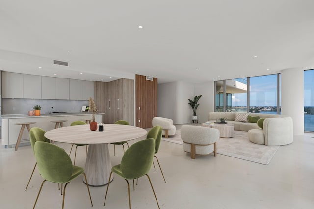 dining space featuring floor to ceiling windows and sink