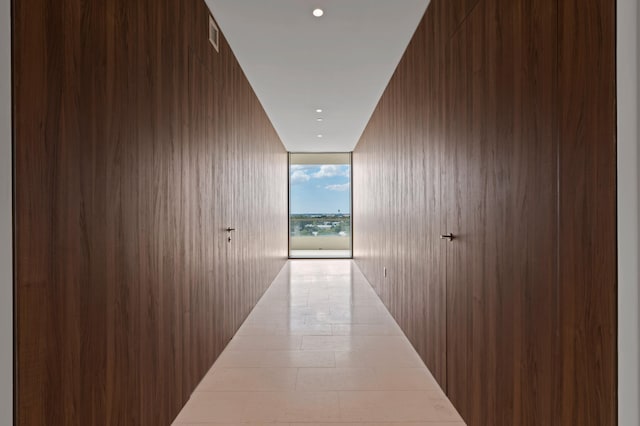 corridor with a wall of windows and wooden walls