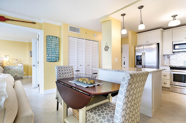 dining room featuring light tile patterned floors, baseboards, visible vents, and crown molding