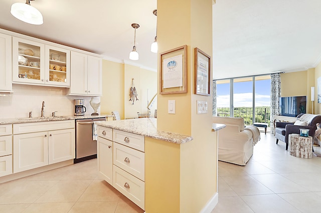 kitchen featuring crown molding, light tile patterned floors, backsplash, stainless steel dishwasher, and a sink