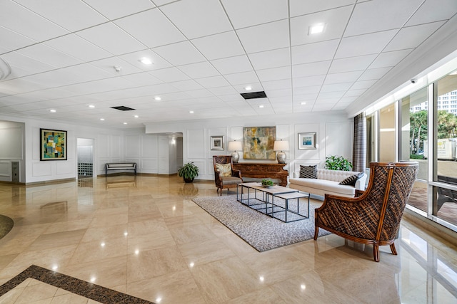 living room with visible vents, a decorative wall, crown molding, and recessed lighting