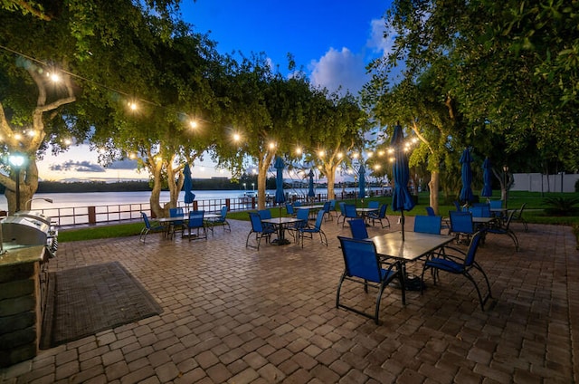 view of patio featuring a water view, fence, and area for grilling