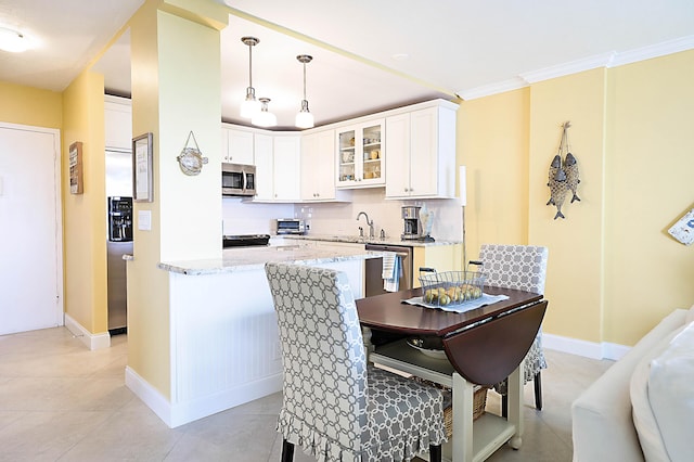 kitchen featuring stainless steel appliances, decorative backsplash, glass insert cabinets, white cabinetry, and a sink