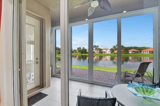 sunroom / solarium with a water view and ceiling fan