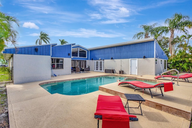 view of swimming pool with french doors and a patio