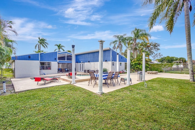 rear view of house with a lawn and a patio