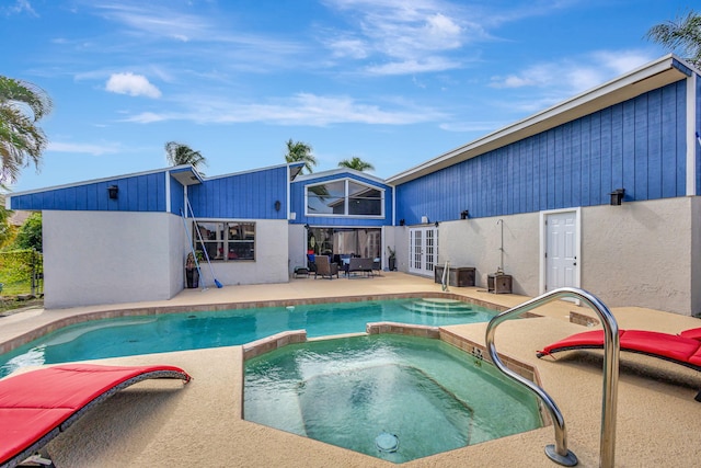 view of swimming pool featuring an in ground hot tub, french doors, and a patio area