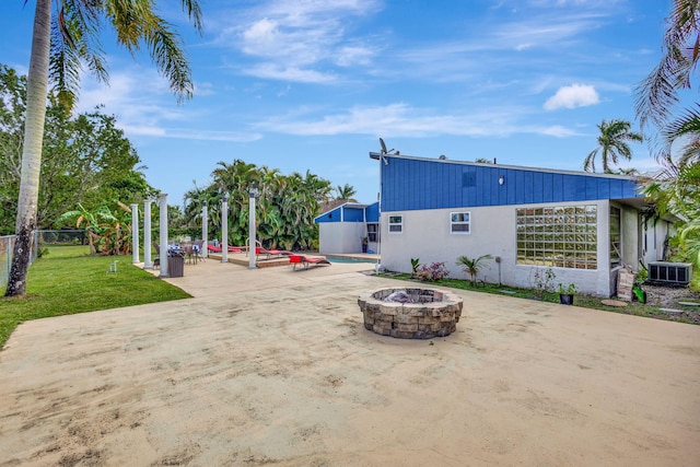 view of patio featuring cooling unit, a fire pit, and a pool